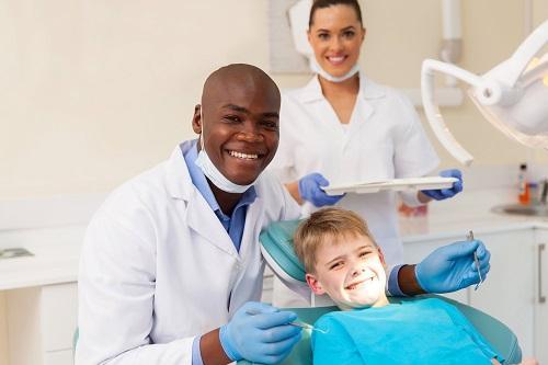 man smiling with child in dental chair